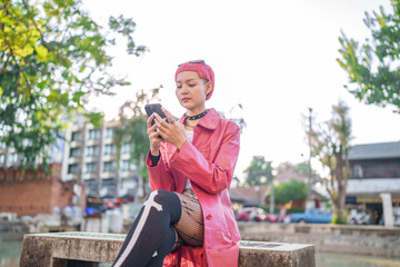 Traveler girl using mobile phone on street in city Fashion gen z asian woman .Technology connection...