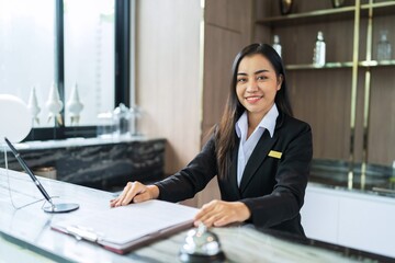 Beautiful asian hotel receptionist in  uniforms at desk in lobby Friendly and welcome staff in...