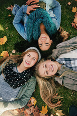 Above, friends or portrait on grass for lying, relaxing and bonding together in park with happiness. Nature, girls and teens on summer holiday for chilling, hanging out and laugh outdoors with smile