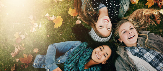 Above, friends or girls on grass for lying, relaxing and bonding together in park with happiness....