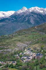 A mountain range with a small village in the valley below. Town of Liri. Benasque Valley. Pyrenees. Huesca. Spain