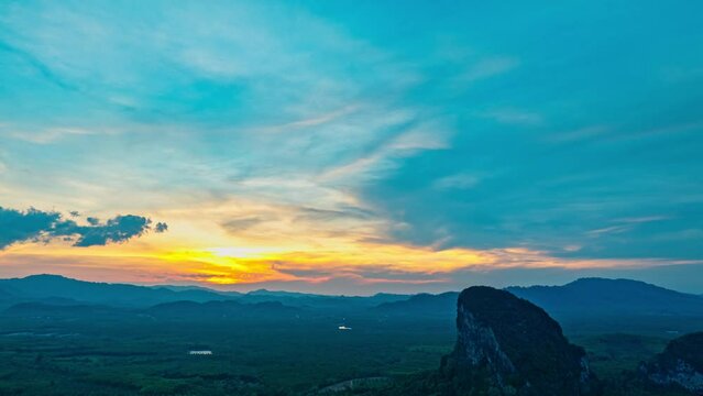 aerial hyper lapse view Amazing light of nature cloudscape above mountain range in Phang Nga. 
High peaks wonderful morning sunset natural Landscape. 
Beautiful sunset tropical landscape background.