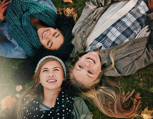 Top view, teen girls and grass for lying, relaxing and bonding together in park with happiness. Nature, lawn and friends on summer holiday for chilling, hanging out and laugh outdoors with smile