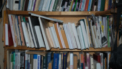 
Bookshelf with books, blurred background.
