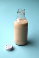 Yogurt in a glass bottle. Milkshake on a blue background. Place for inscription. Yogurt in a glass bottle. Advertising of healthy food. Low-calorie snack. Organic drink