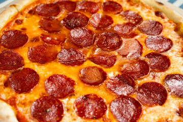 Italian pepperoni pizza with cheese on a wooden board, close-up