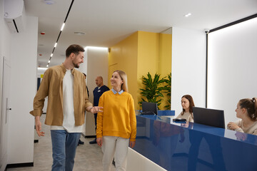 Happy man and woman with walking through modern clinic hall