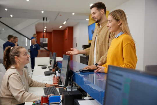 Man and woman couple talking to receptionist at family clinic center