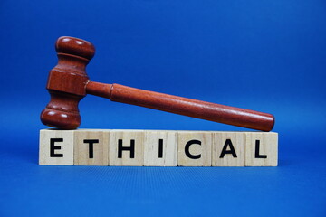 Ethical alphabet letters with wooden blocks alphabet letters and Gavel on blue background