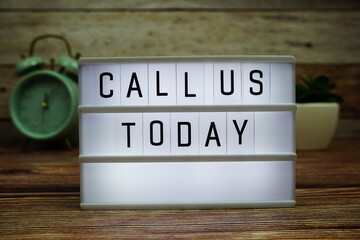 CALL US TODAY letterboard text on LED Lightbox on wooden background, Business and Communication concept background