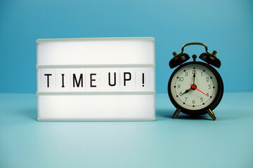 Time Up! letterboard text on LED Lightbox and alarm clock on blue background