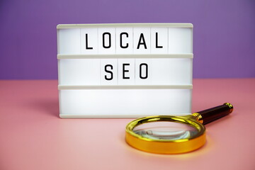 Local SEO letterboard text on LED Lightbox and magnifying glass on pink and purple background