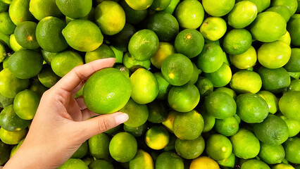 Close-up on a woman picking-up a lime at the market