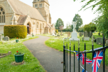 Shallow focus of union jacking bunting seen at the entrance to an English church which has a public...