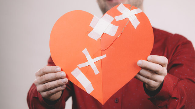 Man holding broken heart. Heartbreak