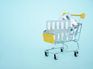 Capsules in blisters with medicines in a grocery cart. The concept of buying medicines at a pharmacy