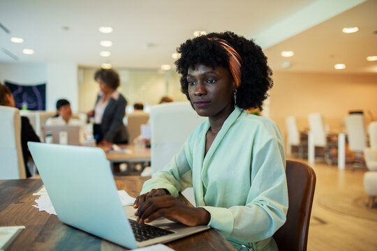 Young adult businesswoman working on laptop in office