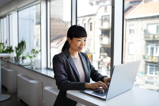 Young adult businesswoman working on laptop in office