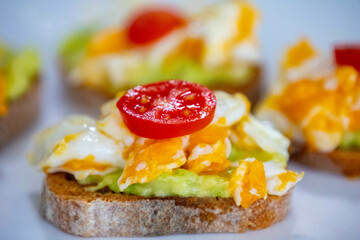 Healthy breakfast, toast with avocado, eggs and tomatoes