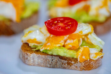 Healthy breakfast, toast with avocado, eggs and tomatoes