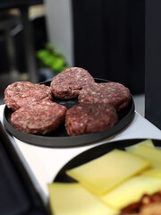 raw meat for hamburger on a plate prepared for grilling