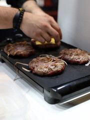 chef making meat burgers and melted cheese on a grill