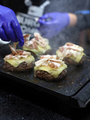 elaboración de hamburguesas con carne y queso fundido con beicon