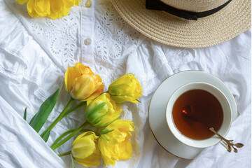 Cup of coffee, tulip flowers and French sweet macaroons.