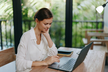 Home Office Freelancer Woman Using Laptop for Online Business A young woman is sitting at her cozy...