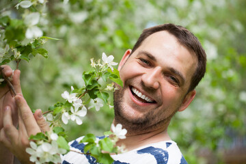 Close up portrait of a young men in a blooming garden