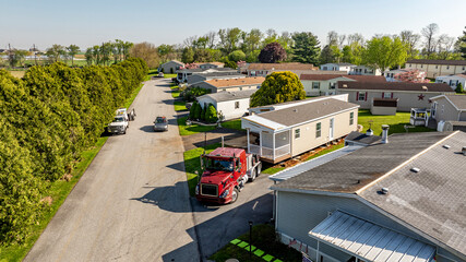 An Aerial View of a Manufactured, Mobile, Prefab Double Wide Home Being Installed in a Lot in a Park