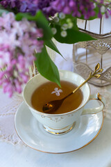 Cup of tea, bouquet of lilacs, spring still life.