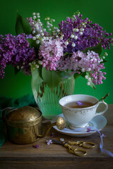 Cup of tea, bouquet of lilacs, spring still life.