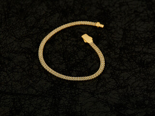 Gold chain bracelet on blakck background