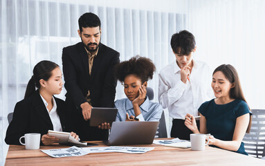 Multiracial analyst team use BI dashboard data to analyze financial report on meeting table. Group...