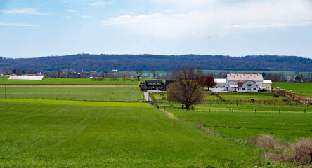 A large field with a farmhouse in the distance
