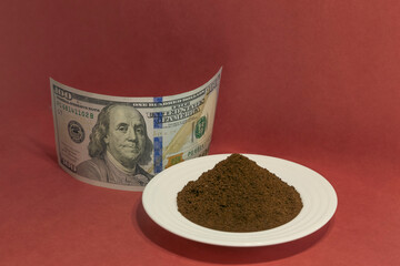 A little pile of ground coffee next to a dollar bill indicating coffee business and international...