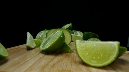 Close-up, a vibrant slice of fresh lime rests upon a rustic wooden cutting board, exuding freshness...
