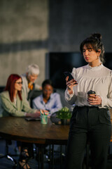 Professional businesswoman with cellphone in hands typing messages.