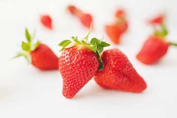 Strawberries isolated over white background. Heap of fresh strawberries on blurred background, selective focus.