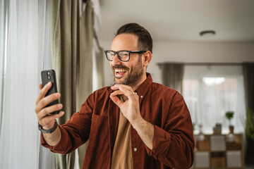 Portrait of adult caucasian man have video call via mobile phone