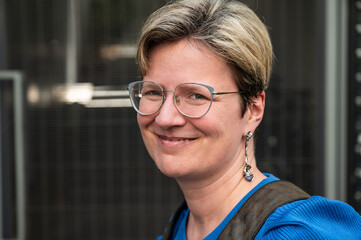 Portrait of an 38 yo white woman wearing glasses and a blue shirt, Belgium