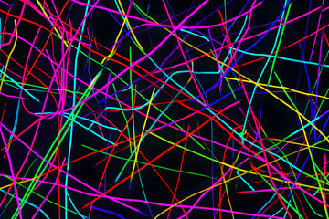 Vibrant neon lines intersecting in a chaotic pattern. Stunning abstract art on black background.