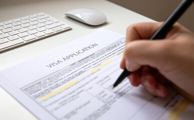 Close up of a female hand filling out a visa application document