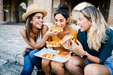 Three multiracial tourist friends having fun eating italian pizza during vacation Travel and holiday lifestyle concept.