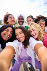 Obraz premium Vertical group of young smiling multiracial only women taking selfie photo looking at camera outdoor. Cheerful beautiful female friends with positive face emotions. Girls Power diversity and community