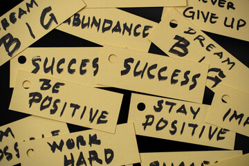 Depicts several yellow tags with motivational phrases written in bold black letters.