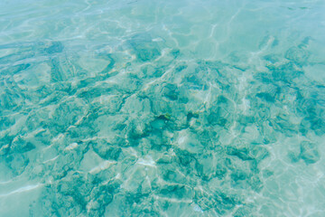 Sun lights shadow in wavy water on abstract sand background