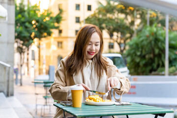 Portrait of Happy Asian woman having lunch at outdoor restaurant during shopping in the city....