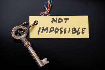 Key with NOT IMPOSSIBLE written on paper